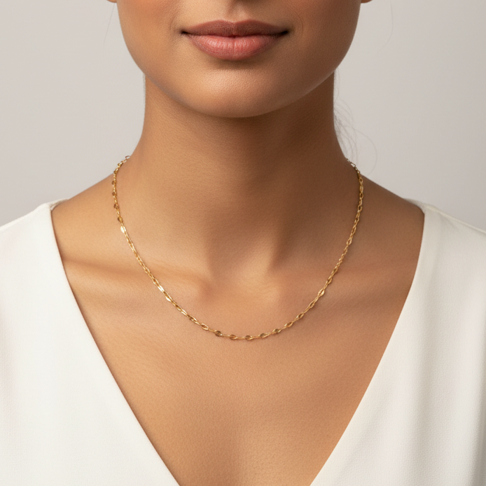 Gold necklace on a model against a neutral background