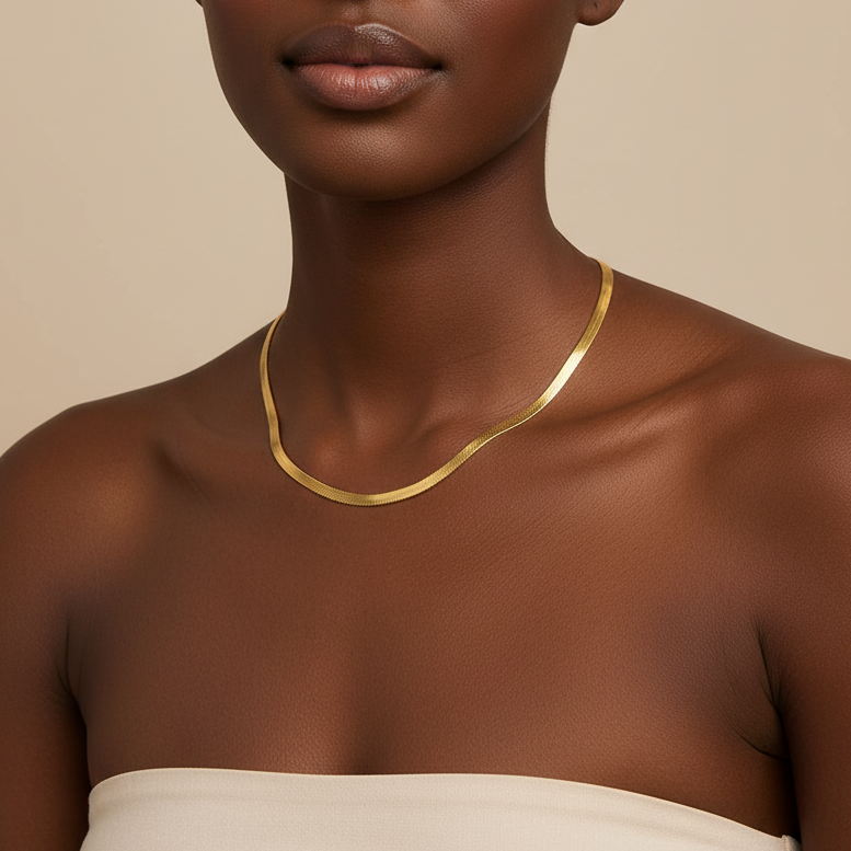 Woman wearing a gold necklace against a beige background