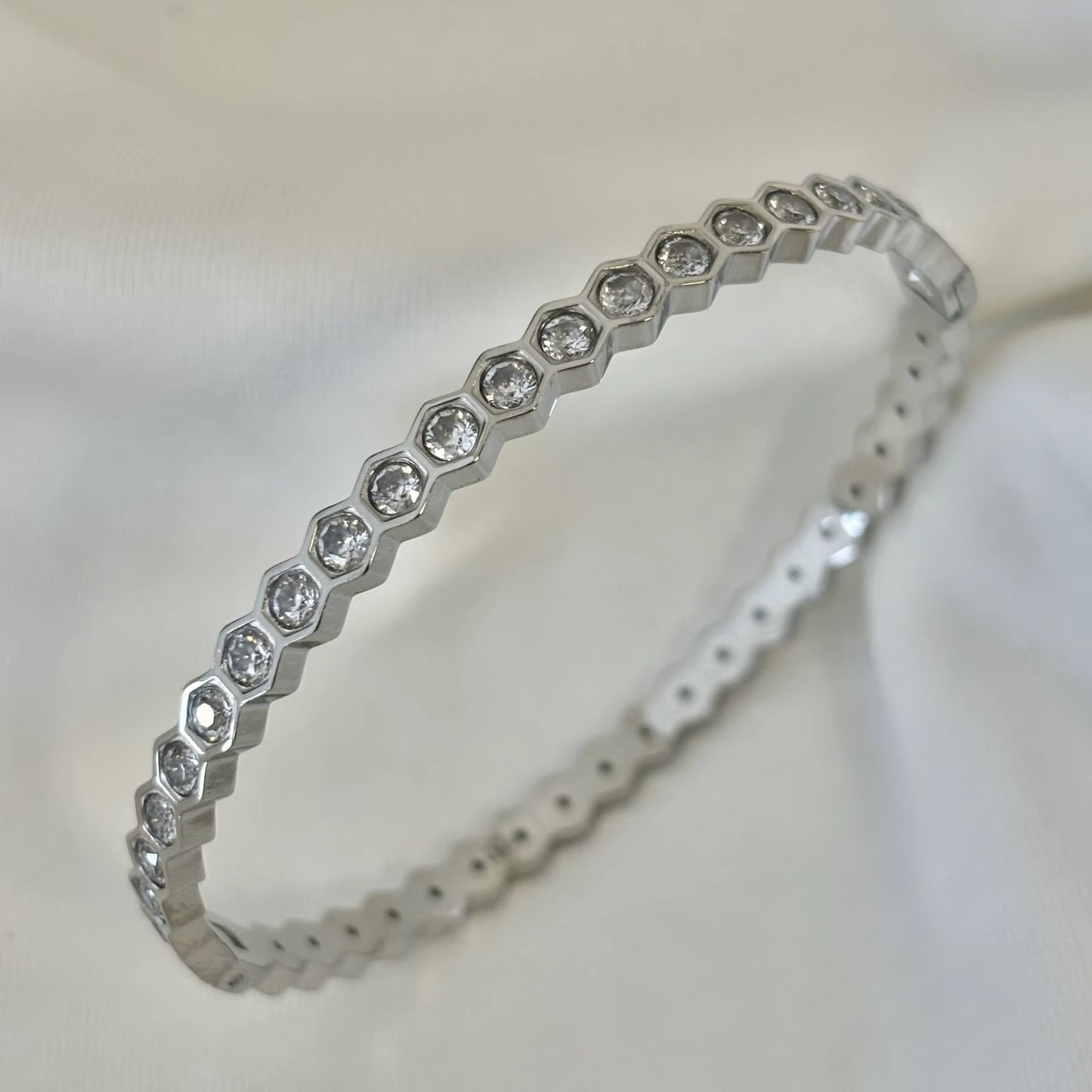 Silver bracelet with diamond accents on a light background