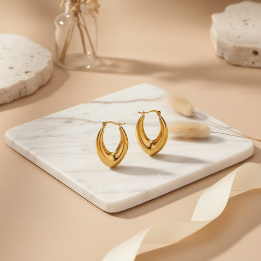 Slim elongated gold hoops with a sleek polished finish.