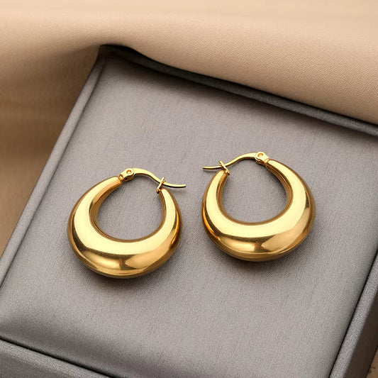 Bold chunky crescent-shaped gold hoops with a smooth sculptural finish.