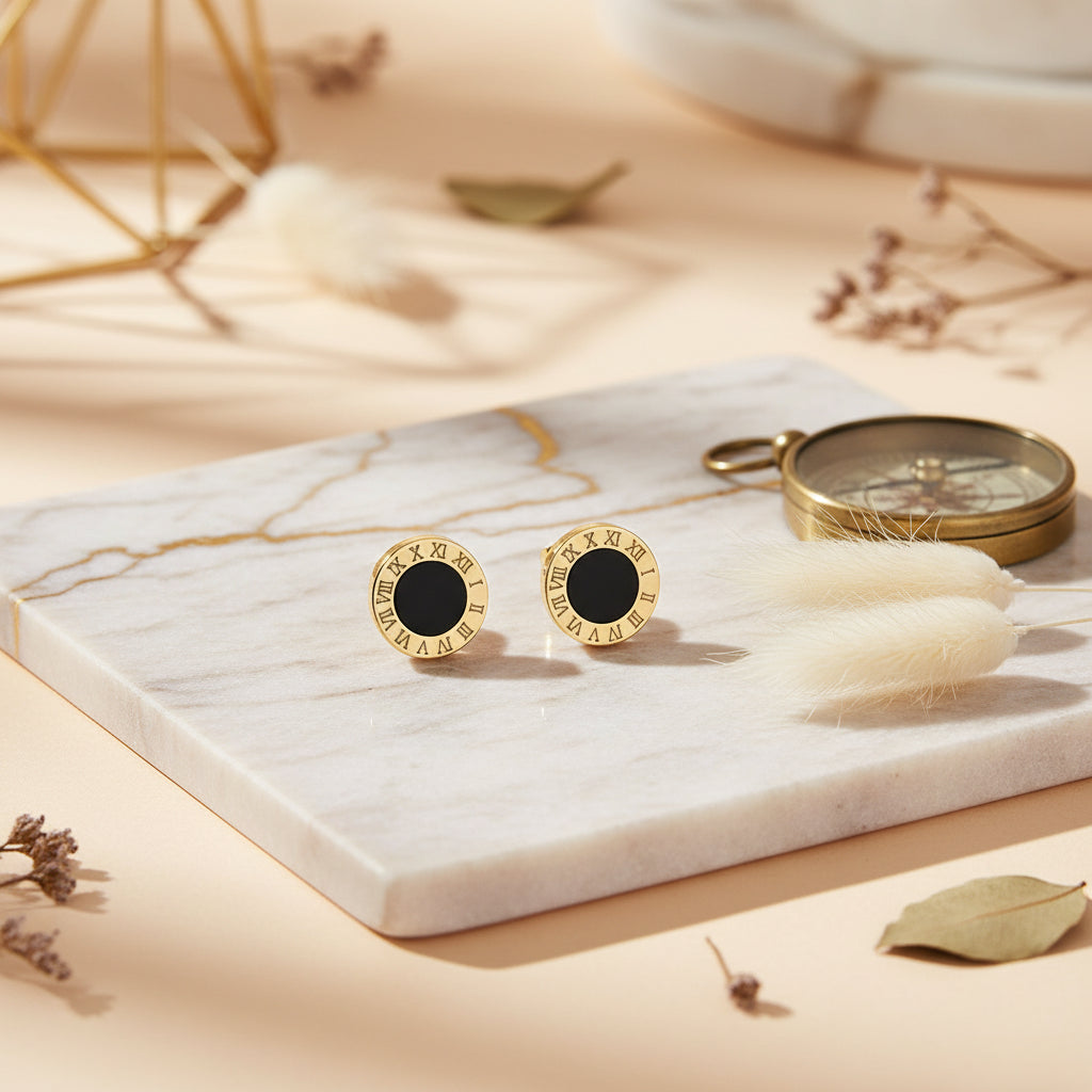 Modern gold circle studs with a black enamel centre and Roman numeral frame.