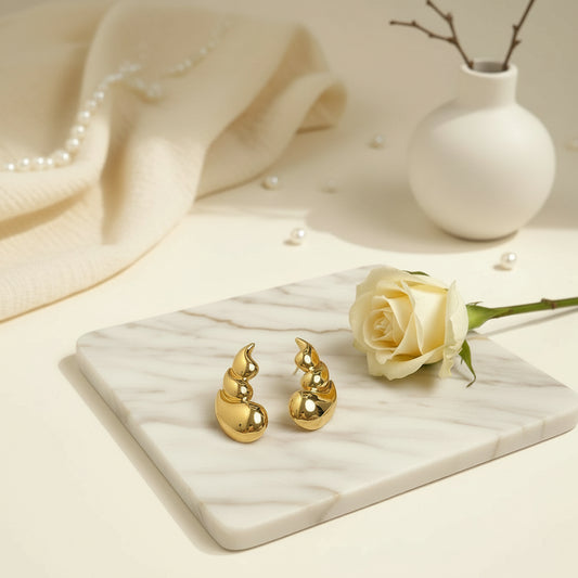 Sculptural gold earrings inspired by cascading water droplets.