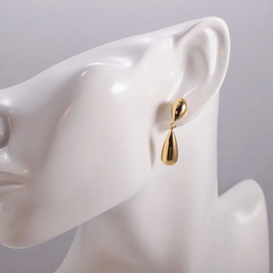 Minimal liquid-gold double drop earrings with a sculpted silhouette.