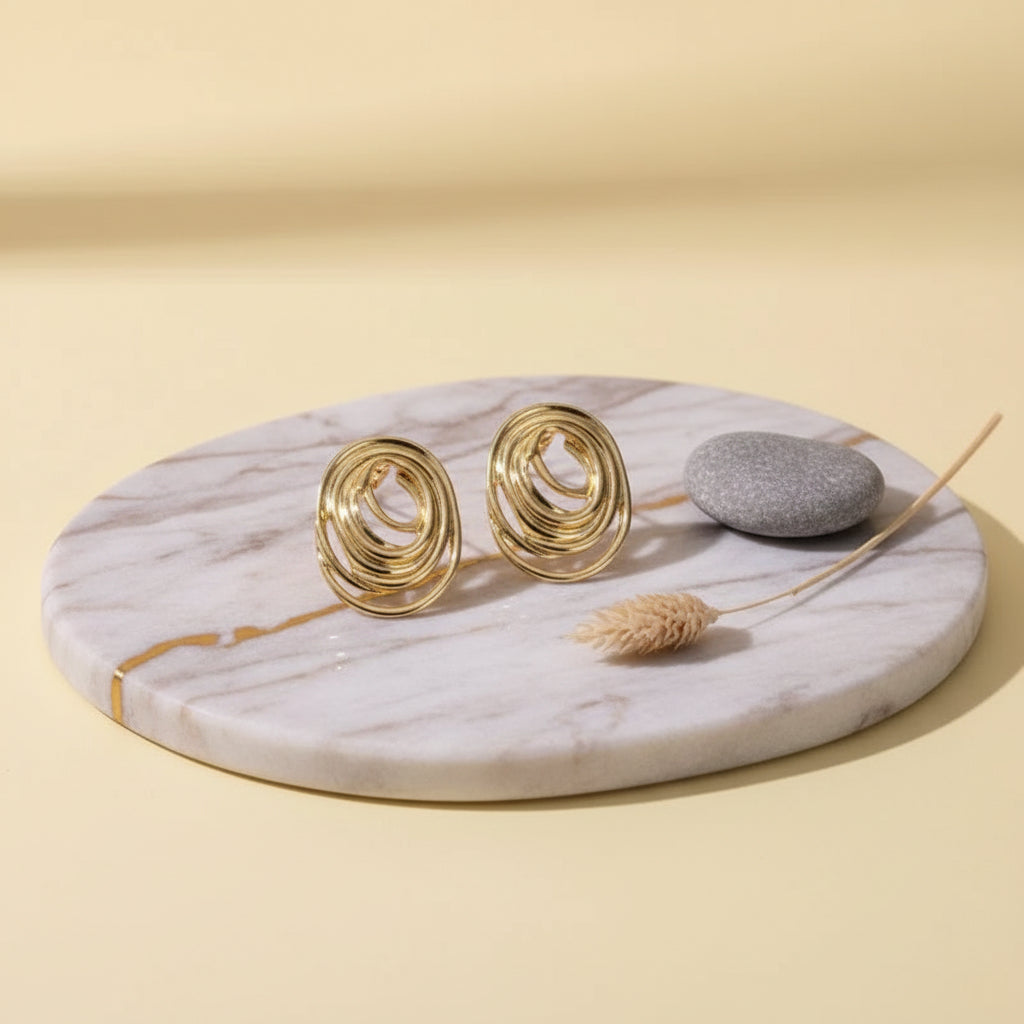 Layered spiral-inspired gold studs with a sculpted modern silhouette.