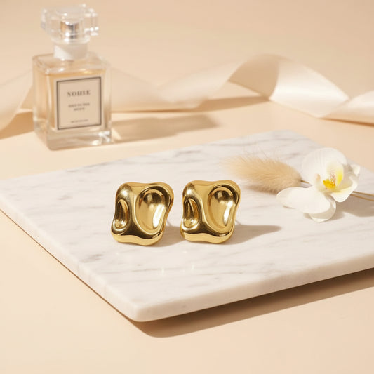 Sculpted rectangular gold studs with softly pressed edges.