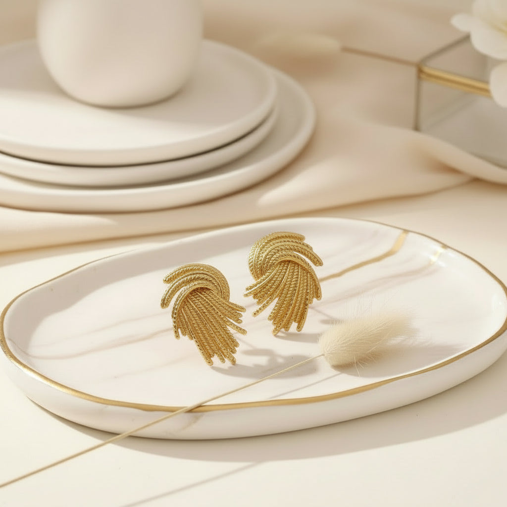 Sculpted gold studs with a twisted, thread-like texture.